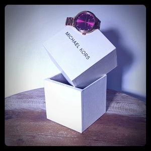 Gold Michael kors watch with a pink face plate